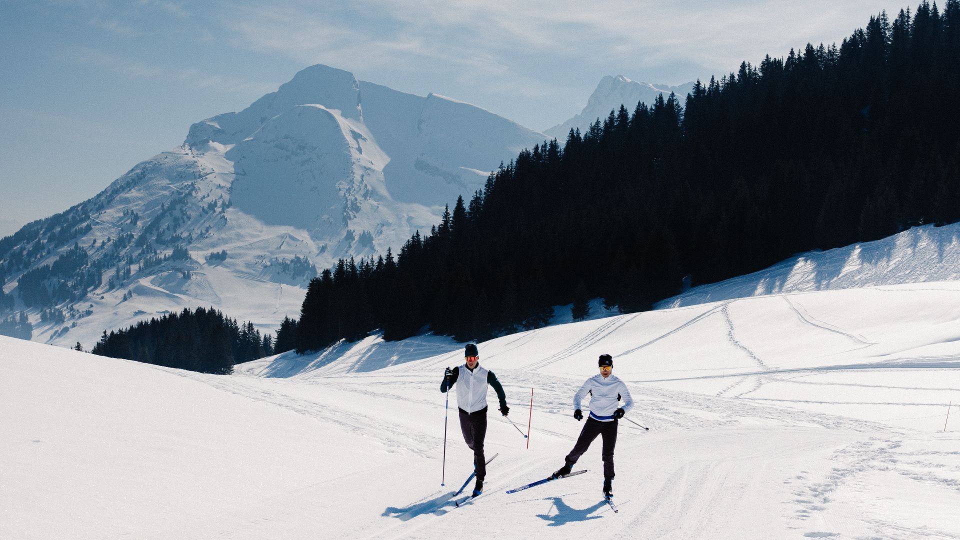 Två personer åker längdskidor i fjället